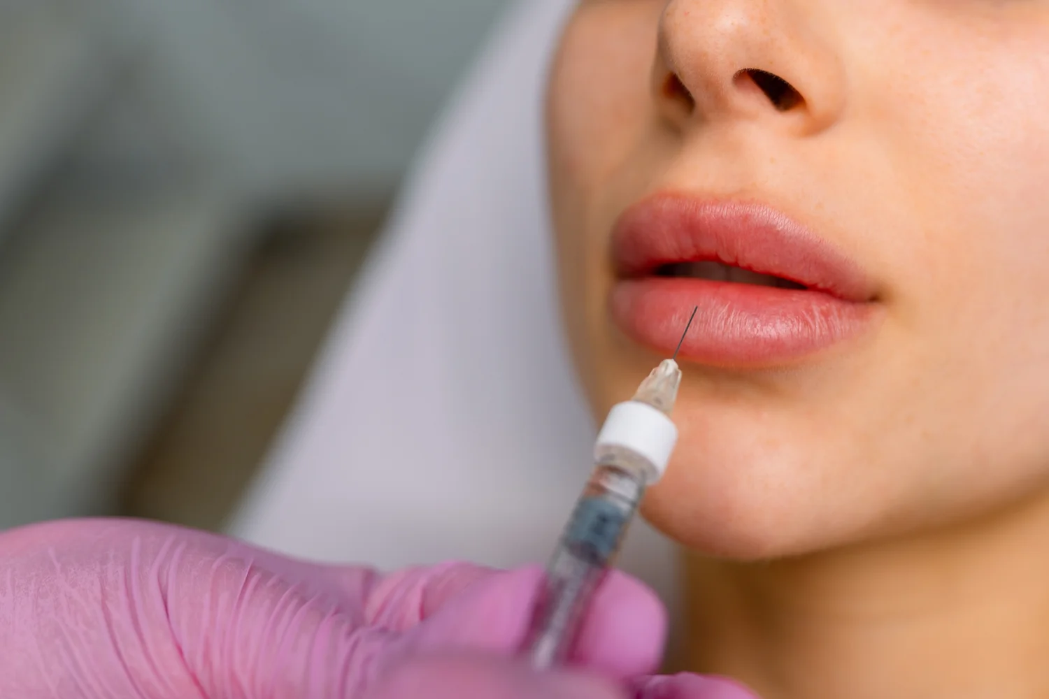 Man receiving facial treatment with syringe in medical facility.